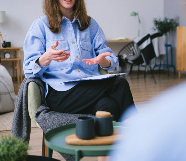 A therapist consults with a client in a contemporary office, focusing on mental health.